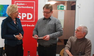 Mirko Witkowski überreicht Hilde Mattheis eine Jubiläumsschrift. Mit auf dem Foto ist Hans Jörg Fahrner. Foto: mp